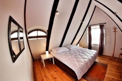 a bedroom with a bed and two mirrors on the wall at Hostel HOMEr - Old Town Square in Prague