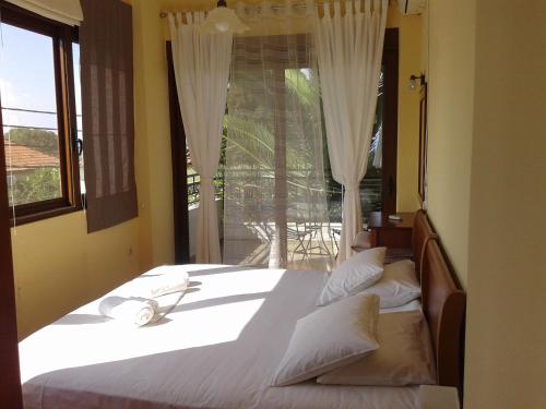 a bedroom with a large bed with a window at Ostria Maisonettes and Studios in Stoupa