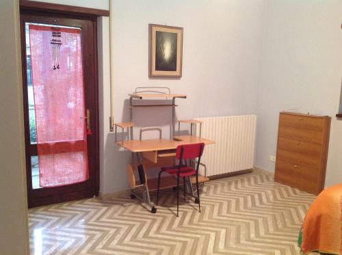 um quarto com uma mesa e cadeiras num tapete em Bed & Breakfast da Charlie em LʼAquila