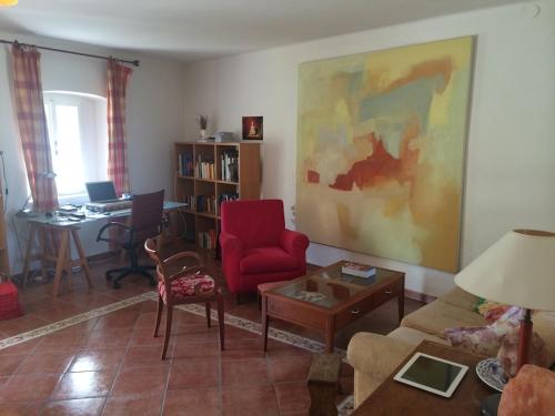 a living room with a red chair and a table at Casa Verità in San Daniele del Friuli