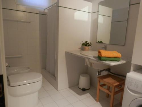 a white bathroom with a toilet and a sink at Dèpendance Argentario in Porto Santo Stefano