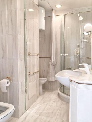a white bathroom with a sink and a toilet at Cordelia 6 in Luino