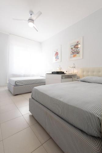 una camera da letto bianca con due letti e una scrivania di Punta Ala Luxury Villa a Punta Ala