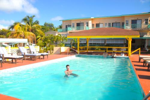 un hombre en la piscina de un hotel en Bird Rock Beach Hotel en Basseterre