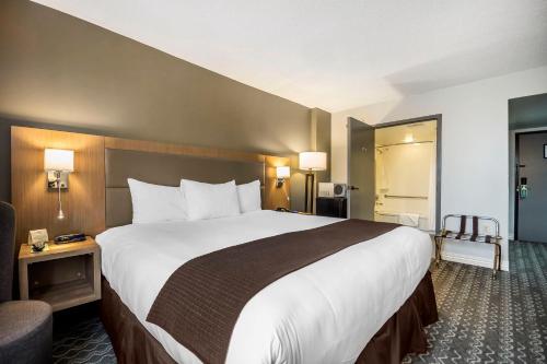a hotel room with a large bed and a chair at Best Western Plus Vancouver Airport Hotel in Vancouver