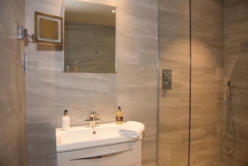 a bathroom with a sink and a mirror at Roundthorn Country House & Luxury Apartments in Penrith