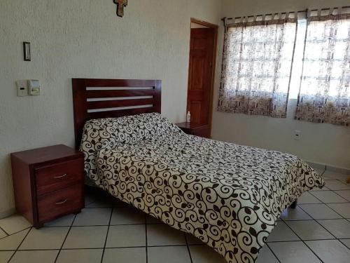 una camera da letto con un letto con un piumone bianco e nero di Casa los Peregrina a Cuernavaca