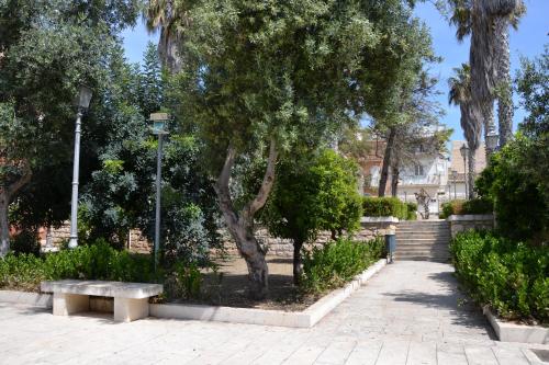 a park with a bench and a tree and stairs at Donnalucata Ospitalità Diffusa in Donnalucata