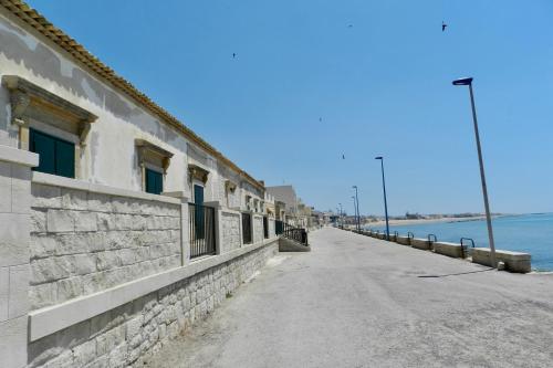 an empty street next to a building next to the ocean at Donnalucata Ospitalità Diffusa in Donnalucata