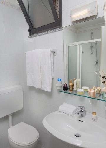 a bathroom with a sink and a toilet and a mirror at Hotel Piccadilly in Bellaria-Igea Marina