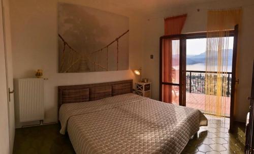 a bedroom with a bed and a large window at Pandora 1 in Maccagno Inferiore