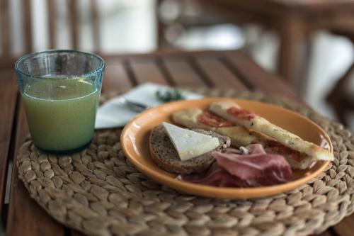 a plate of food and a glass of green juice at Residenza Santa Cecilia in San Vincenzo