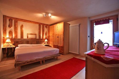 a bedroom with a bed and a television in it at Maso Toneto in Castello di Fiemme