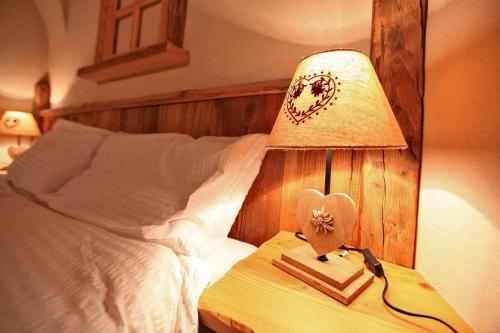 a bedroom with a bed with a lamp on a table at Maso Toneto in Castello di Fiemme