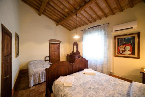 1 dormitorio con 2 camas y ventana en Tenuta di Montemassi Podere Raspollino, en Montemassi