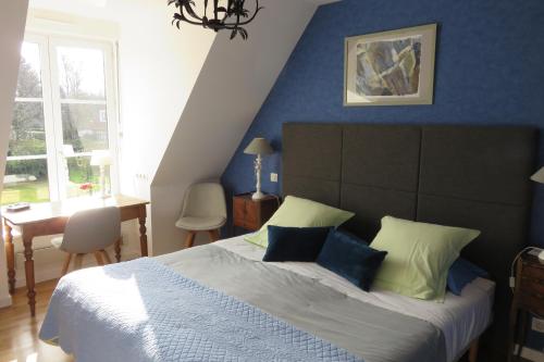 a bedroom with a large bed with blue walls at A la Maison du Héron in Villeneuve d'Ascq