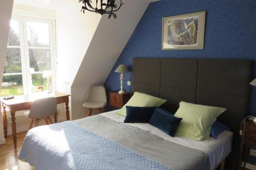 una camera da letto con un letto grande con pareti blu di A la Maison du Héron a Villeneuve d'Ascq