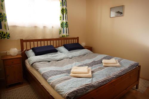 a bedroom with a bed with two towels on it at ECOmfort Apartment in Kecskemét