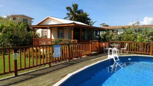 a house with a wooden deck and a swimming pool at The Pool House in Saint Philip