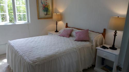 - une chambre dotée d'un lit avec des oreillers roses dans l'établissement The Pool House, à Saint Philip