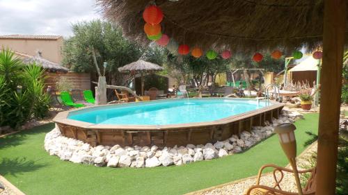 a swimming pool with rocks around it in a yard at Gite Saint Julien in Argelès-sur-Mer