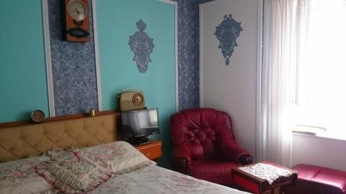 a bedroom with a bed and a chair and a television at Willa Zamkowisko in Gołubie