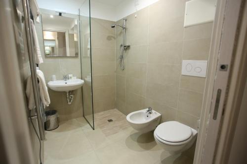 a bathroom with a toilet and a sink and a shower at Hotel Eubea in Reggio Calabria