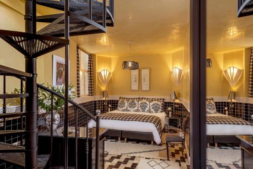 1 dormitorio con 2 camas y escalera en Riad Karmela Princesse, en Marrakech