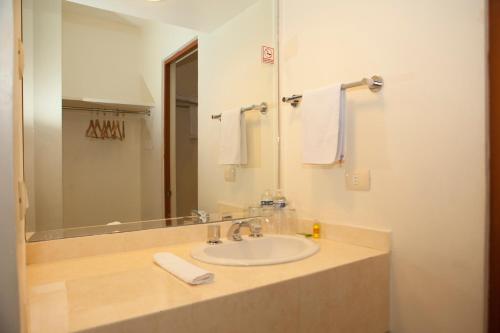 La salle de bains est pourvue d'un lavabo, d'un miroir et de serviettes. dans l'établissement Hotel Paradise Inn, à Ciudad Victoria