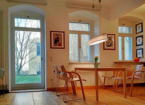 a dining room with a table and chairs and a window at Neustadt - Paradies in Dresden