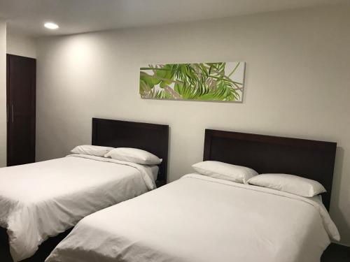 two beds sitting next to each other in a room at Hotel Plaza in Santiago