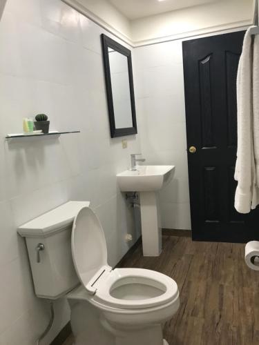 a bathroom with a white toilet and a sink at Hotel Plaza in Santiago
