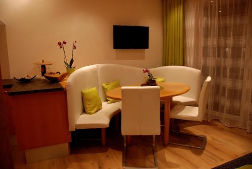 a living room with a table and chairs and a kitchen at Apartment Serlesblick in Ellbögen