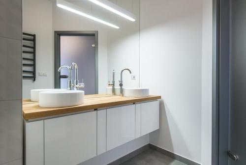 Un baño con dos lavabos y un espejo. en Super-Apartamenty Luxury, en Poznan