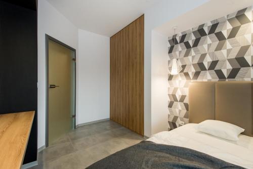1 dormitorio con 1 cama con pared geométrica en Super-Apartamenty Luxury, en Poznan