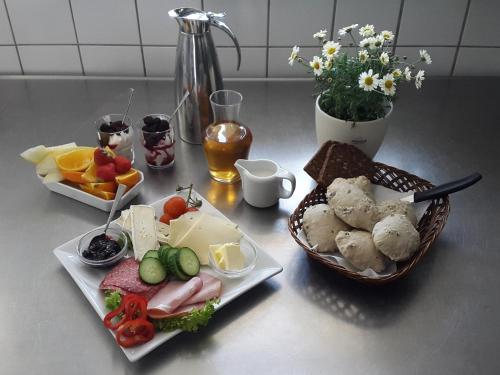 a table with two plates of food and a basket of fruit at Jungshoved Kro B&B in Præstø