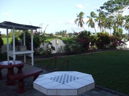 a patio with a table and an umbrella at Huize Sherida in Nickerie in Nieuw Nickerie