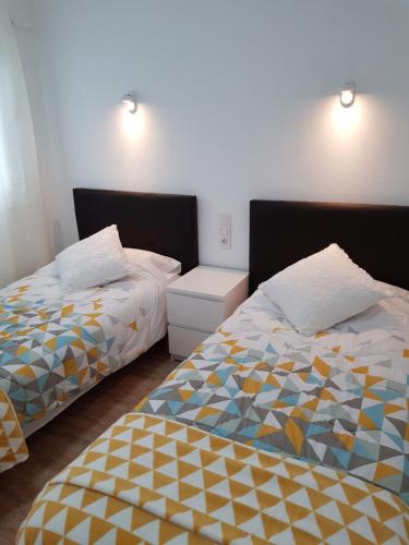 two beds sitting next to each other in a bedroom at Apartamentos Capellania in Puerto del Carmen