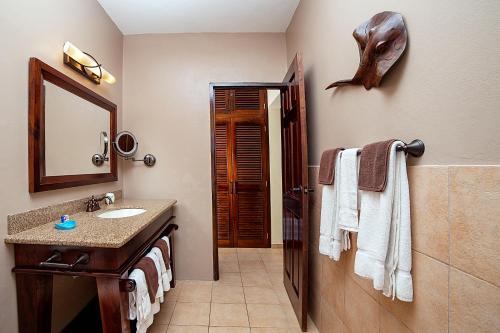 a bathroom with a sink and a shark head on the wall at Beach House Condos, Negril in Negril