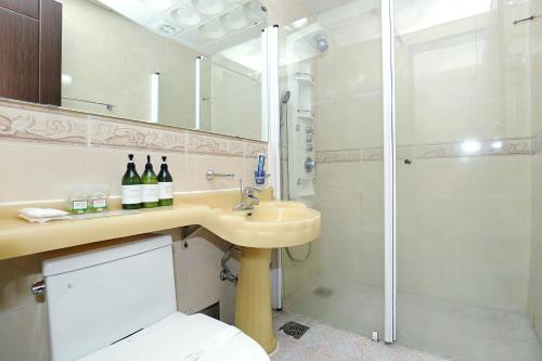 a bathroom with a toilet and a sink and a shower at Suncheon Nobless Hotel in Suncheon