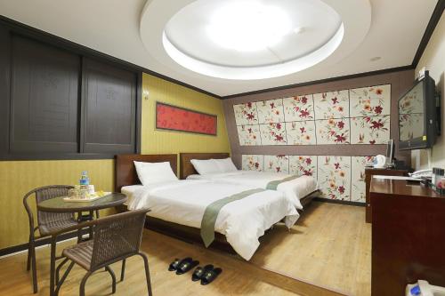 Suncheon Nobless Hotel tesisinde bir odada yatak veya yataklar