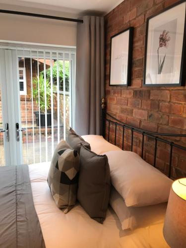 a bed in a room with a brick wall at The Larches in Wolverhampton