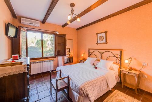 a bedroom with a bed and a television in it at Los Montejos & Spa in Valverde del Fresno