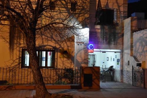 a tree in front of a building with a blue light at Residencial El Hogar in Salta