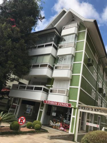 un edificio verde con un cartel delante en Ap Gramado - ALTO PADRÃO, en Gramado