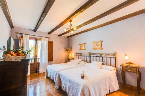 a bedroom with two beds and a television in it at Los Montejos & Spa in Valverde del Fresno