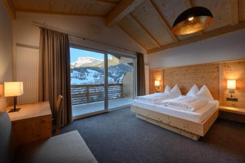 a bedroom with a bed and a large window at Garni August in Ortisei