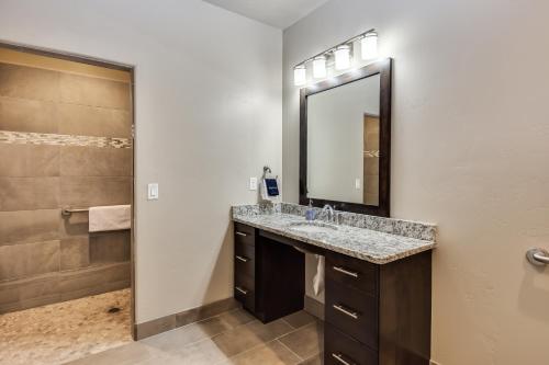 a bathroom with a sink and a mirror and a shower at Watchman Villas in Springdale