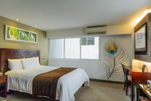 a hotel room with a bed and a window at Riande Urban Hotel in Panama City