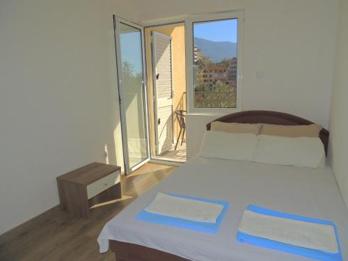 a bedroom with a bed and a large window at Guest House Jelena in Budva
